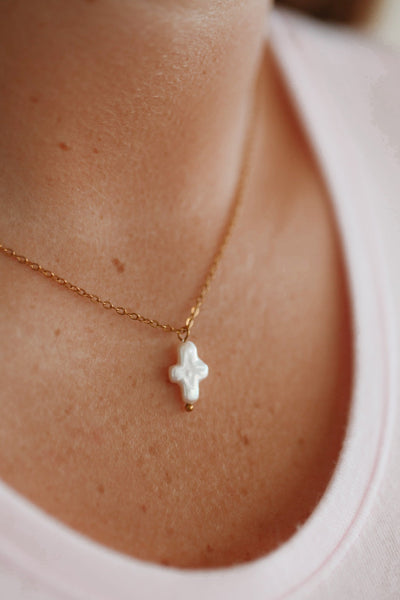 Necklace with a white pendant worn by a person