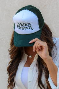 Person wearing a green and white cap with 'Valley Grown' text against a plain background