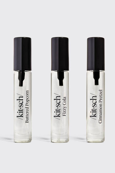 Three Kitsch perfume bottles on a light gray background