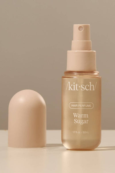 Kitsch hair perfume bottle with cap on a beige background