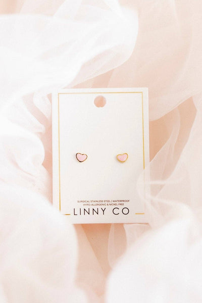 Heart-shaped earrings in a LINNY CO packaging against a soft pink background