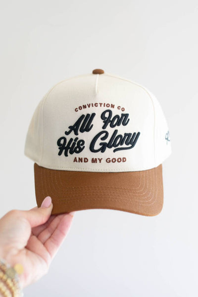 Trucker hat with text held by a hand on a light background