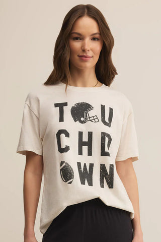 Woman wearing a beige t-shirt with 'TOUCHDOWN' text and football graphic on a beige background