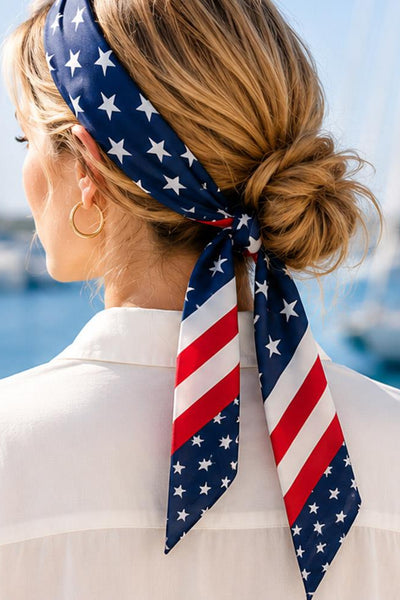 Woman wearing an American flag headscarf with a blurred background of boats on water