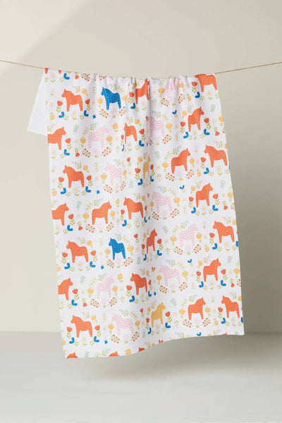 Colorful patterned towel with horse design on a plain background